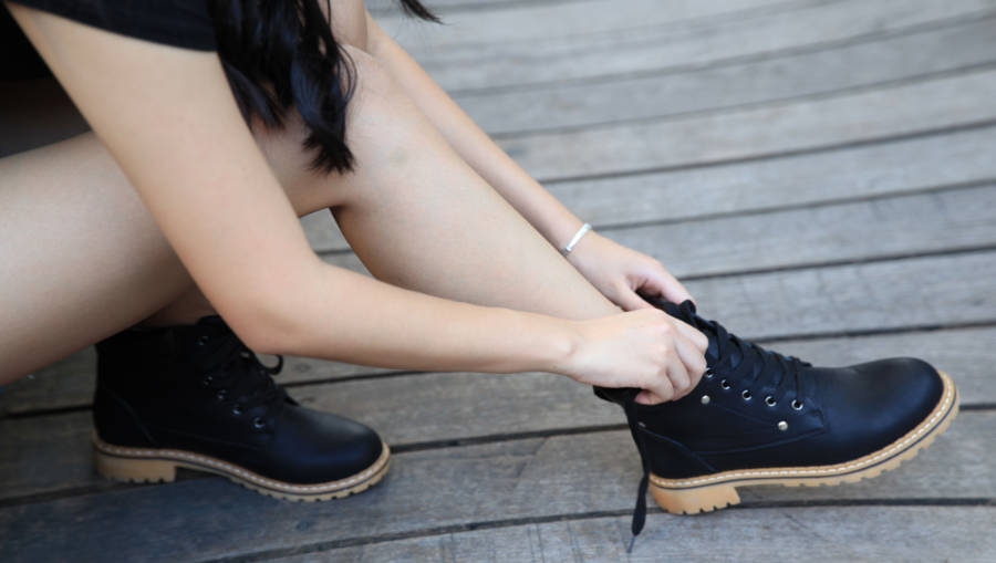 A woman trying on a pair of Dr Martens work boots