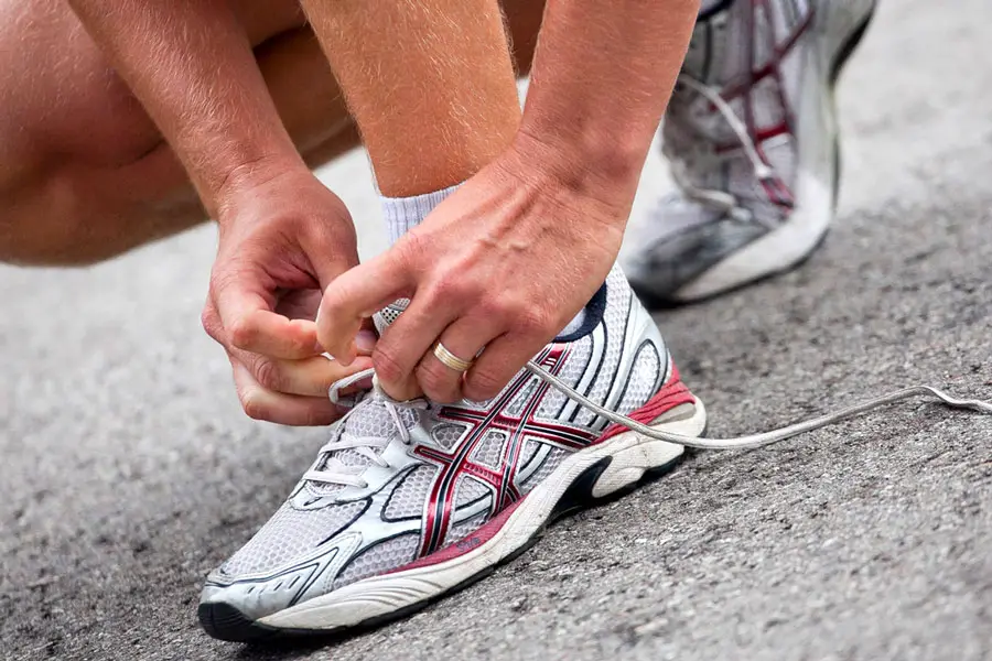 View of an Asics shoes being tied by a runner
