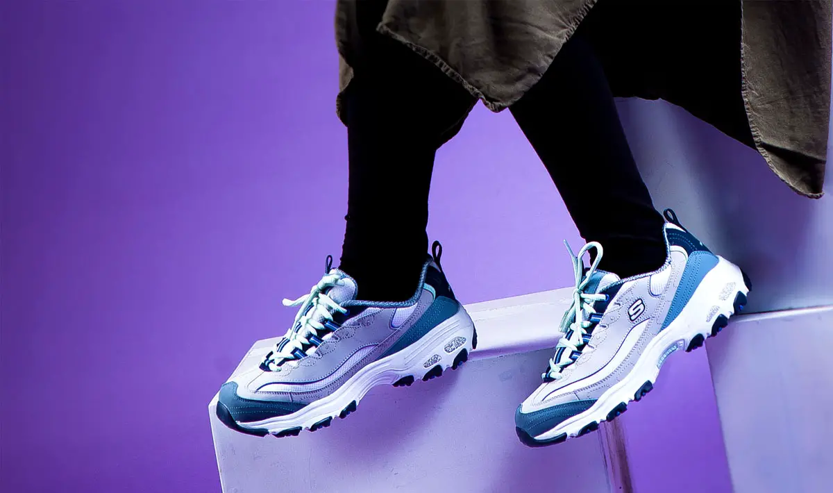 Skechers shoes being worn in a purple background room